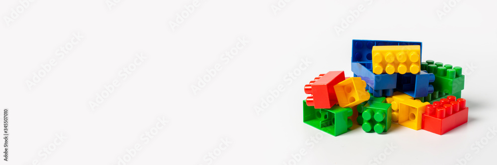 Multicolored designer parts on an isolated white background. Educational toys, logic. Banner Multicolored designer parts on an isolated white background. Educational toys, logic. Banner