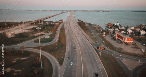 Aerial Establishing Shot Of the Interstate Highway I-45 South connecting the island of Galveston at Sunset, Next to the Old Highway 75, With Moderate Traffic. Wide Shot, Orange and Teal photo