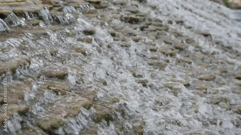 Close up video of crystal clear water running in mountain forest creek. Small water drops splashing, sunny spring day Close up video of crystal clear water running in mountain forest creek. Small water drops splashing, sunny spring day