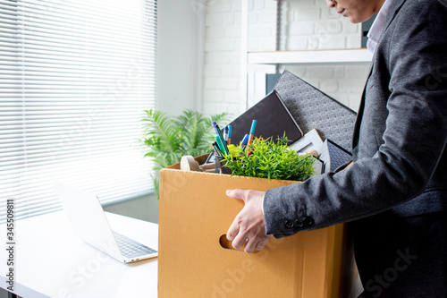 The unemployed worker is putting things in a brown cardboard box to change to a new job.