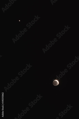 Young Moon and Venus on a dark night sky.