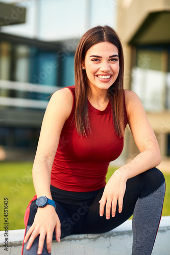 Thirsty young sporty woman making pause after exercising in the park.