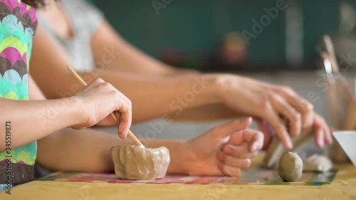 The manufacture of ceramics. Girl sculpts from clay with mother.