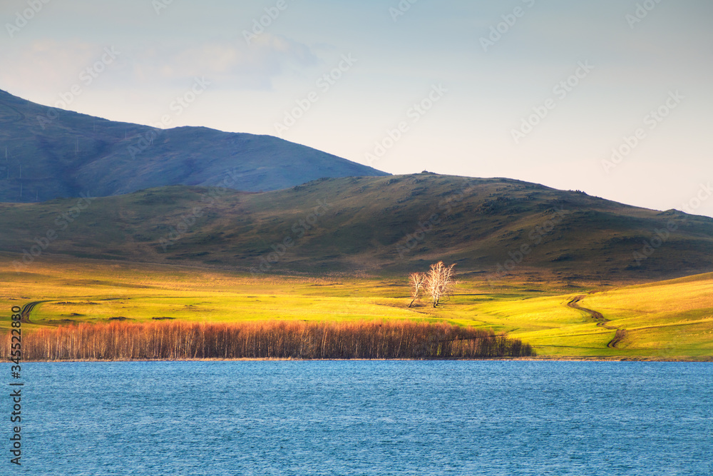 Lake in the mountains at sunset. Spring nature landscape. South Ural, Bashkortostan Republic, Russia.