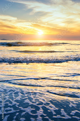 Scenic view of sand beach at the sea in morning sunrise sky.