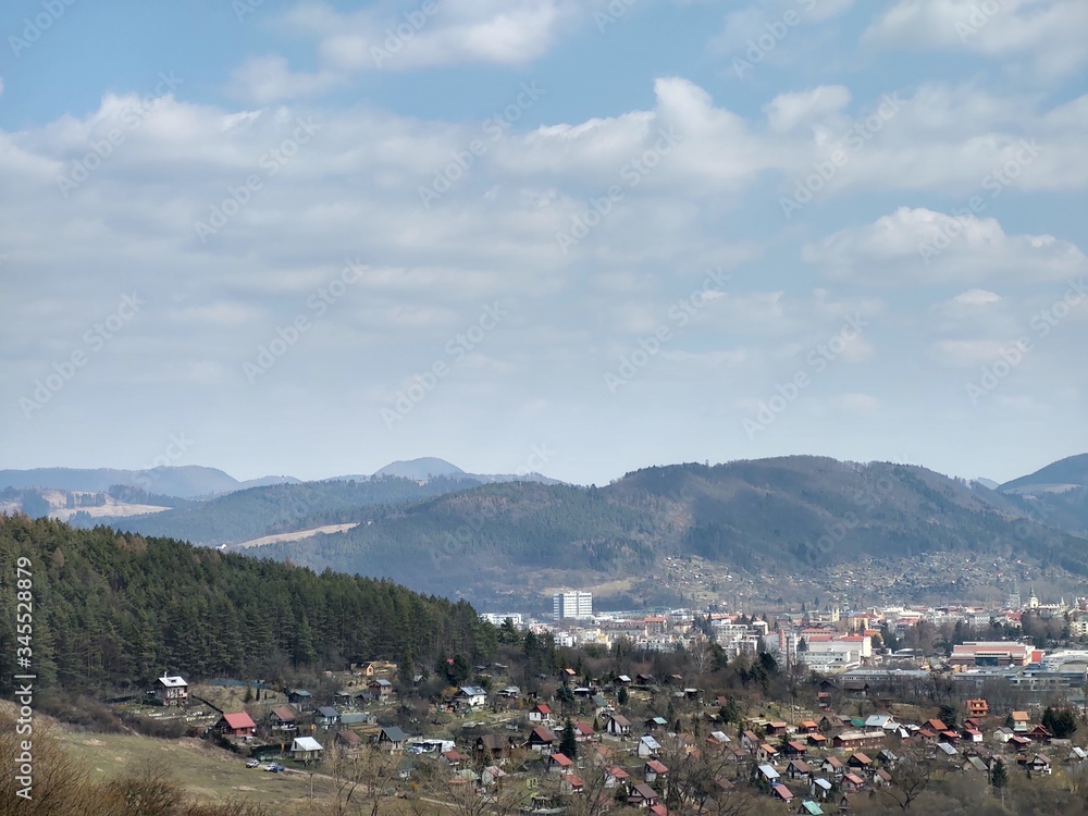 Fototapeta premium Sunrise and sunset, beautiful clouds over the meadow, hills and buildings in the town. Slovakia