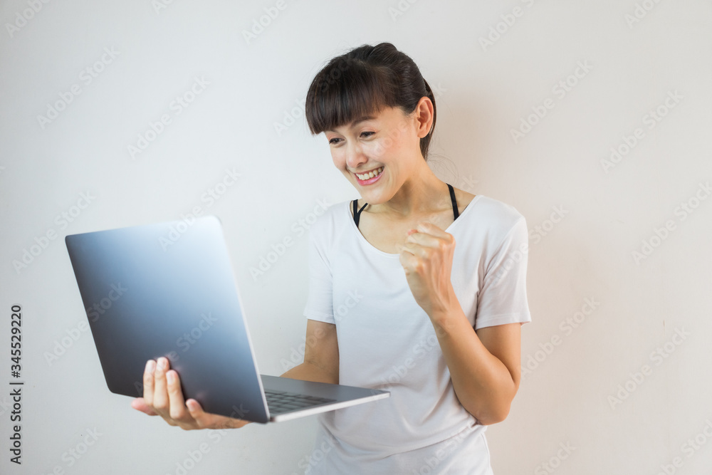 Young woman holding laptop computer and celebrating success Young woman holding laptop computer and celebrating success