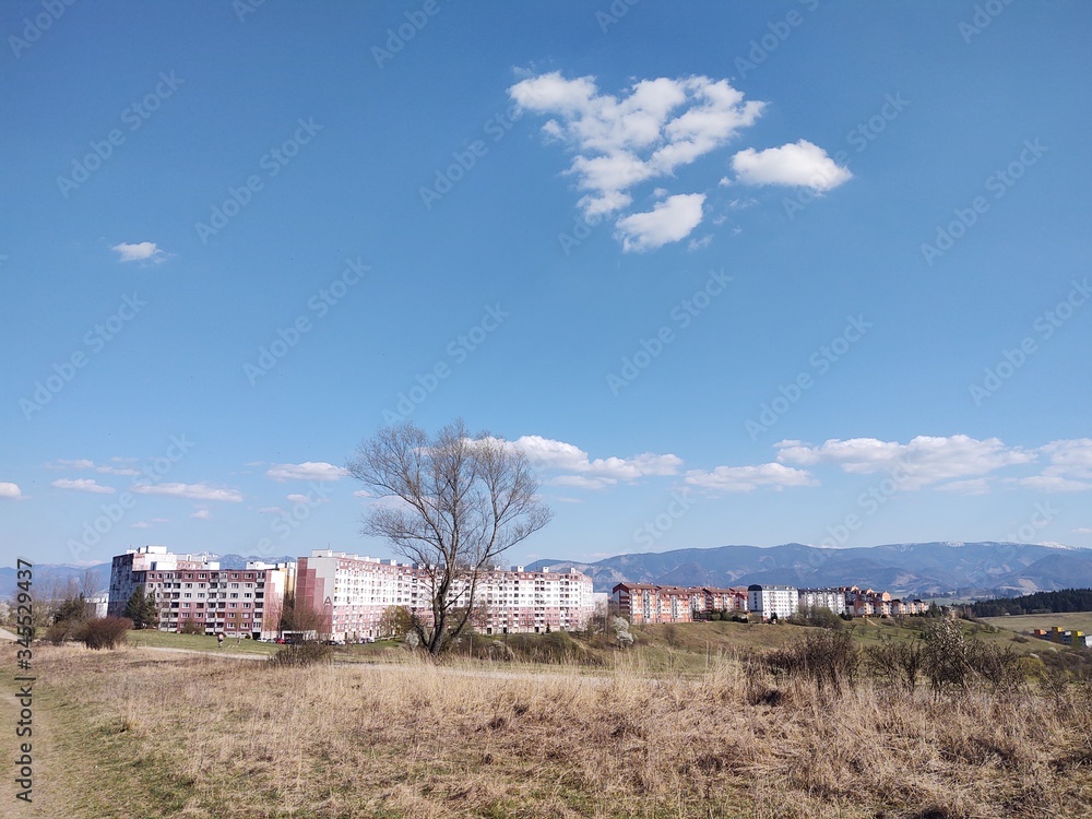 Sunrise and sunset, beautiful clouds over the meadow, hills and buildings in the town. Slovakia