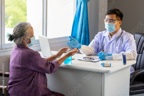 Asian doctor advised the old woman to wash her hands with alcohol before the treatment to prevent the initial corona virus infection.