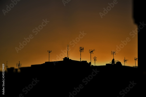  picturesque landscape at sunset with black roofs of houses and antennas
