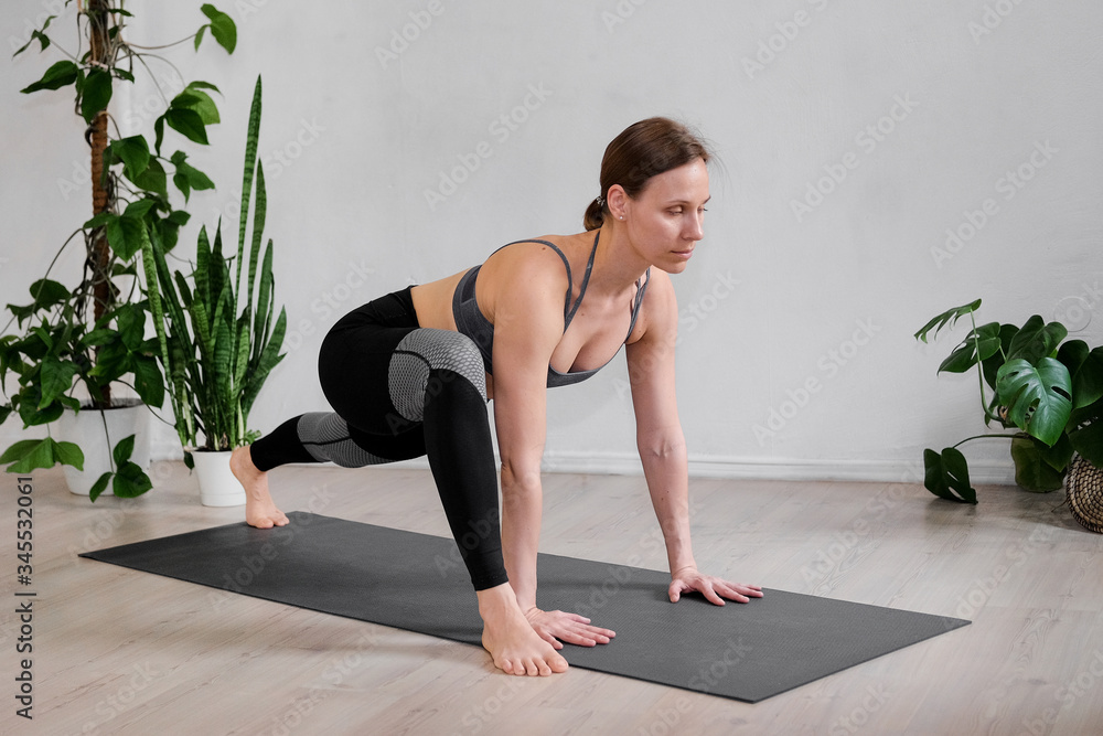 A woman does hatha yoga at home during the quarantine A woman does hatha yoga at home during the quarantine