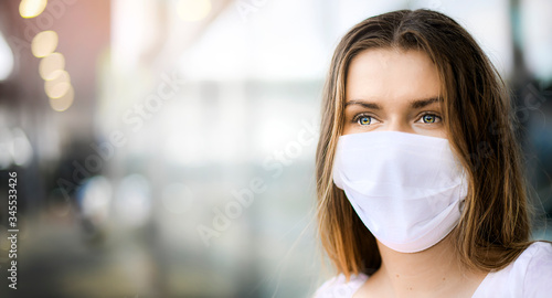 Epidemic Corona Virus masked girl on the blur background of the city. Coronavirus flu travel concept wide banner panorama. Woman in face mask copy space for text