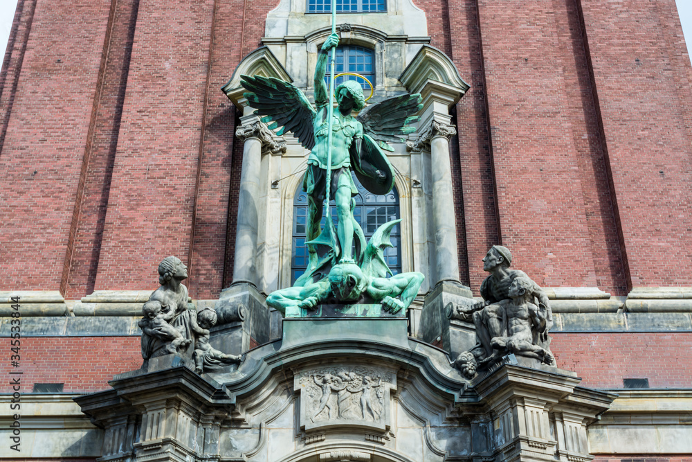 Sculpture of Angel killing a devil in front of Church of St. Michael, Hamburg, Germany. A landmark of the city and it is considered to be one of the finest Hanseatic Protestant baroque churches Sculpture of Angel killing a devil in front of Church of St. Michael, Hamburg, Germany. A landmark of the city and it is considered to be one of the finest Hanseatic Protestant baroque churches