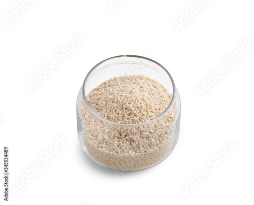 White sesame seeds in glass bowl on white background