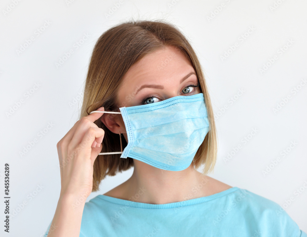 Girl puts a medical face mask for protection against infection. Healthcare and medical concept. Girl puts a medical face mask for protection against infection. Healthcare and medical concept.