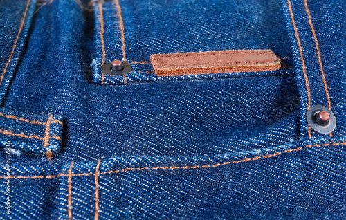 Blank small leather label and cooper rivets on blue jeans
