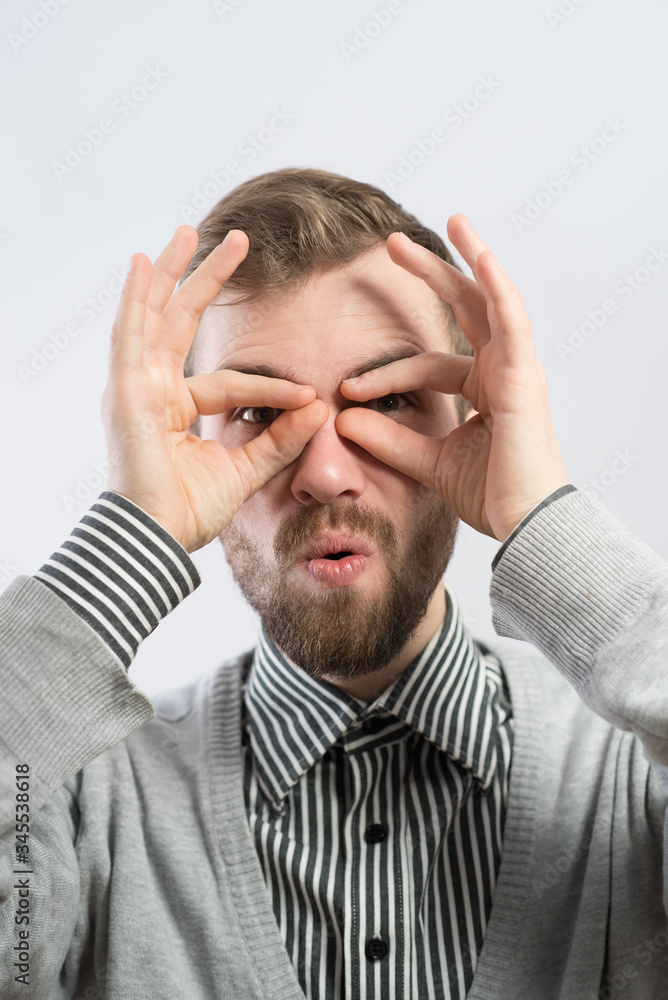 Serious man with hand over eyes, looking through fingers Serious man with hand over eyes, looking through fingers