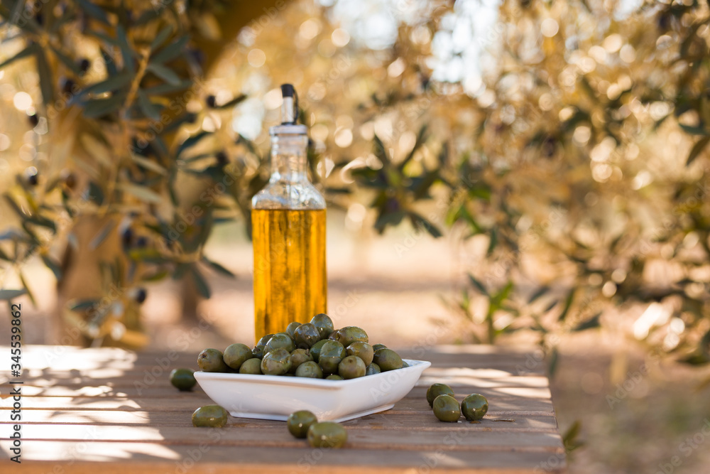 green olives and oil on table in olive grove green olives and oil on table in olive grove