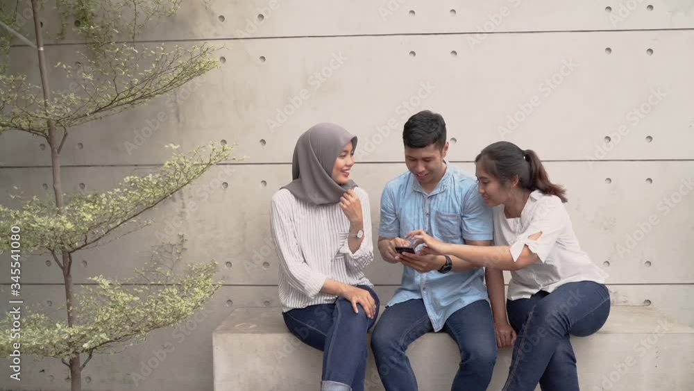 three friend muslim talk and using mobile phone together three friend muslim talk and using mobile phone together