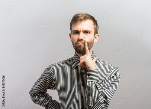 Closeup portrait rude, impolite difficult angry young man, gesturing with finger against temple, are you crazy? Negative human emotions, facial expression, feeling, attitude photo