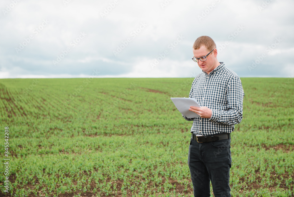 happy farmer in the fields with a laptop computer