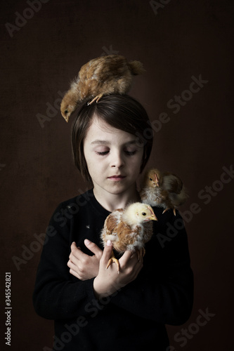 Young preteen boy with chickens in studio