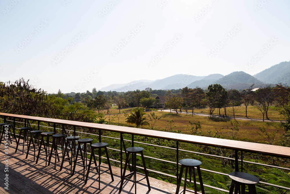 wooden table and mountain landscape scenic at coffee shop .
