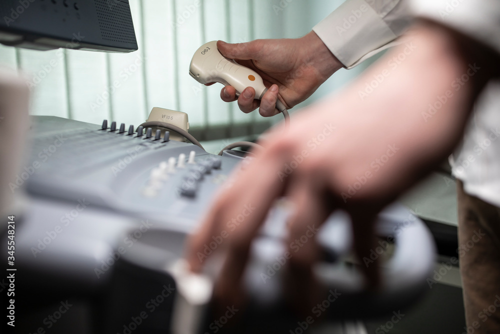 Close up shot of technician operating an ultrasound machine at a clinic. Close up shot of technician operating an ultrasound machine at a clinic.