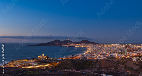 Vista panoramica de la ciudad de Las Palmas de Gran Canaria al anochecer con la playa de las Canteras y las montañas de La Isleta al fondo photo