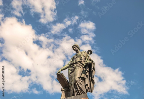 Ancient sculpture (18th century) of  ancient Greek muse of  history of Clio against  background of sky and clouds
