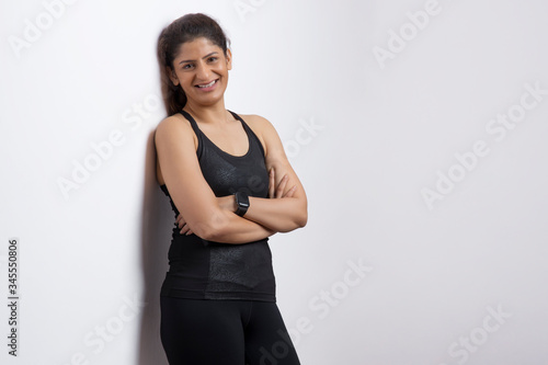 Happy woman standing with her arms folded on her chest. 