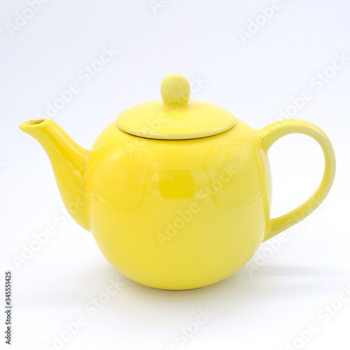 Closeup Yellow teapot on white background, over light