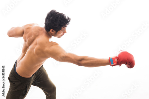 Man throwing punch in the air while wearing boxing gloves in front of a white background,   © IndiaPix