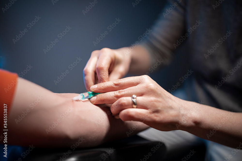 A nurse is inserting a syringe to a patient's vain. 