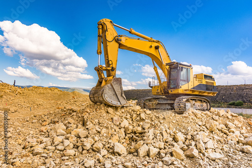 Excavator in a quarry extracting stone