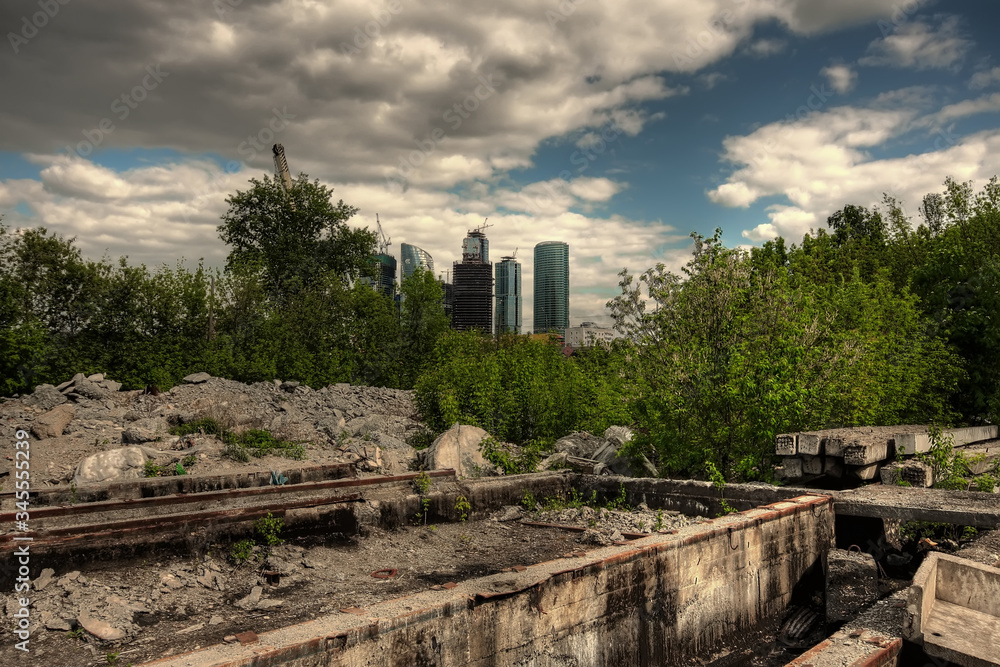 Unfinished buildings behind trees and abandoned territory Unfinished buildings behind trees and abandoned territory