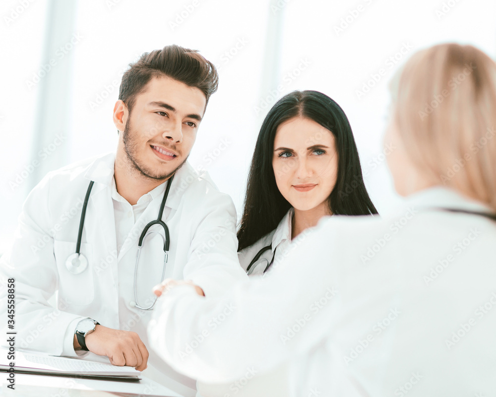 handshake of medical doctors at the Desk . handshake of medical doctors at the Desk .