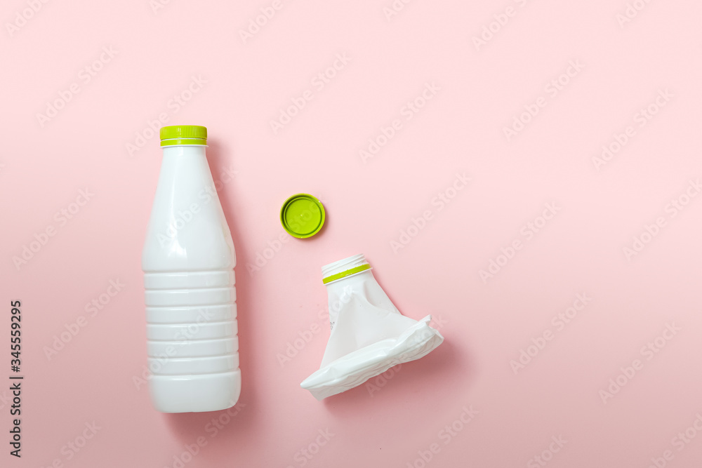 white plastic bottles on a pink background. the problem of waste disposal and recycling. white plastic bottles on a pink background. the problem of waste disposal and recycling.
