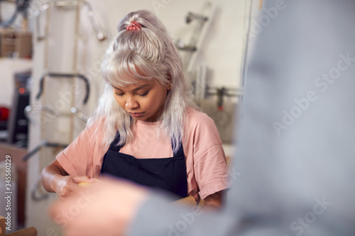 Young Woman In Workshop Assembling Hand Built Sustainable Bamboo Bicycle Frame