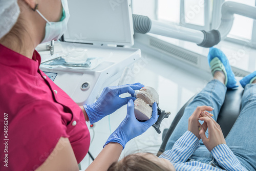 Female dentist doctor holds dental mouthguard in hands, splint therapy in dentistry to correct bite. The concept of health care and treatment in medical facilities