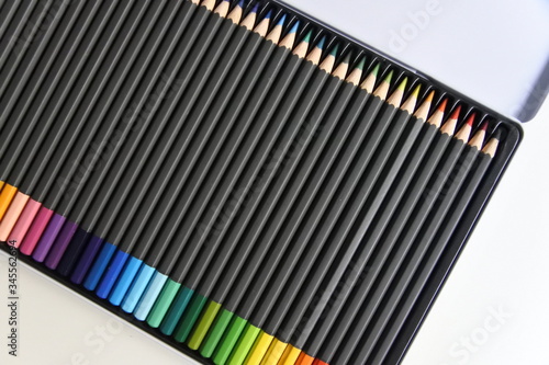 Estuche de lápices de colores de madera. Cuerpo oscuro y colores ordenados como el arco iris. 