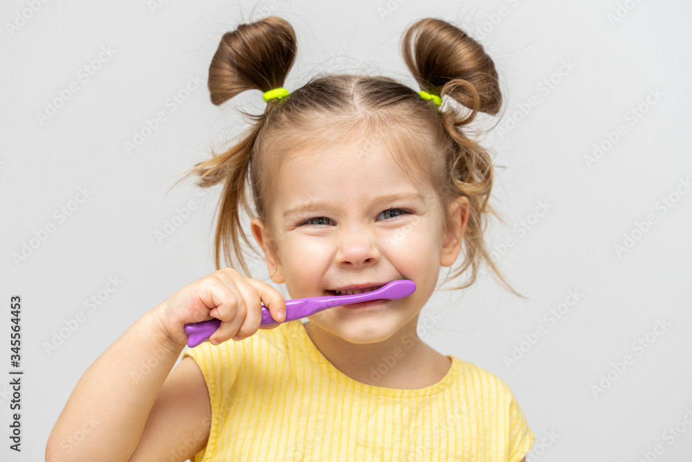 child in a yellow T-shirt with clean teeth brushing on a light background child in a yellow T-shirt with clean teeth brushing on a light background