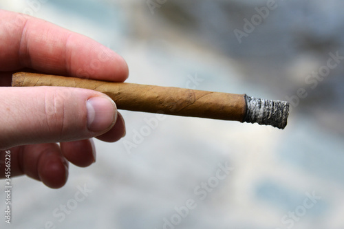 hand with a burnt cigar