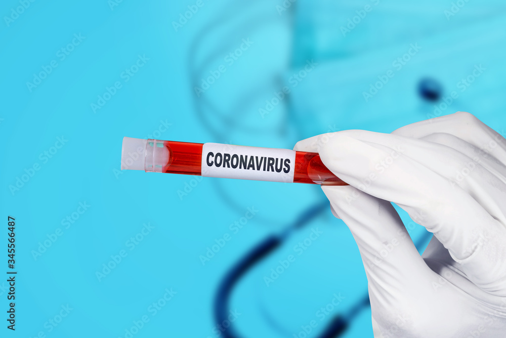 Doctor man in protective gloves holding a test tube with a coronavirus blood sample Doctor man in protective gloves holding a test tube with a coronavirus blood sample