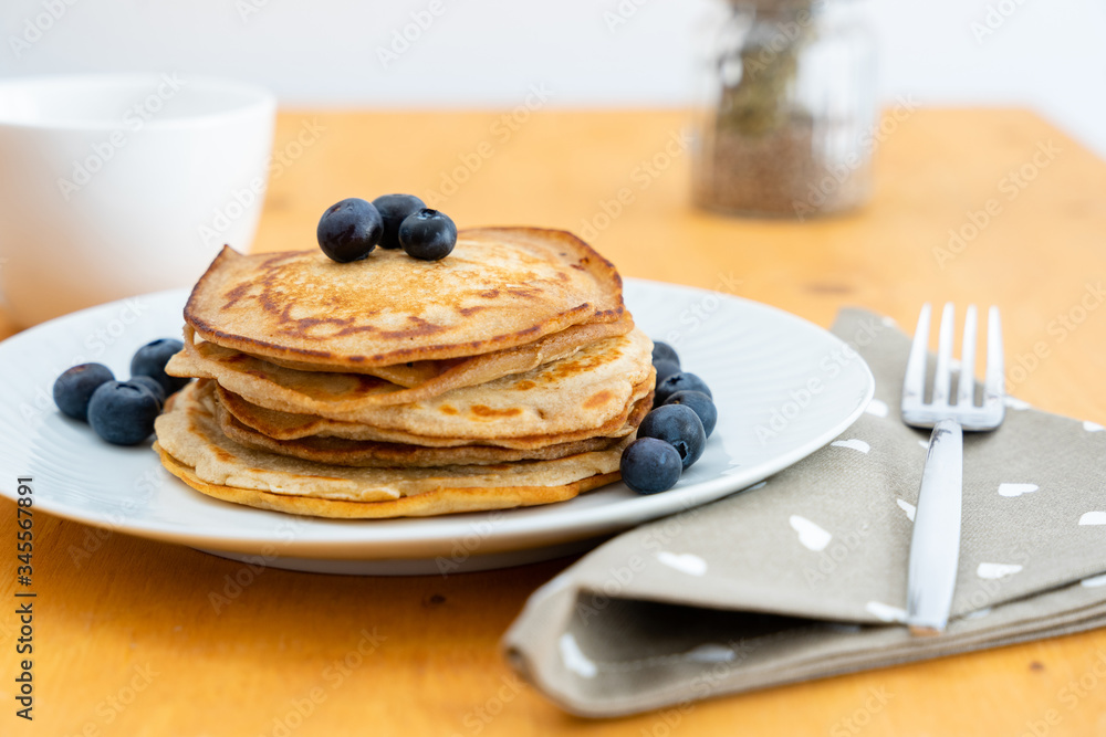 Homemade pancakes arranged on a white plate with blueberries - Copy space Homemade pancakes arranged on a white plate with blueberries - Copy space