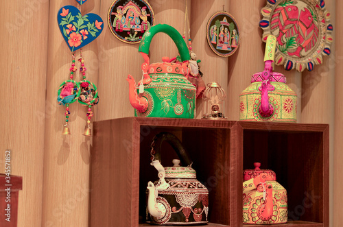 Painted colorful decorative traditional Indian kettles, dreamcatchers and wind chimes on display in a retail store in Dilli Haat, New Delhi, India