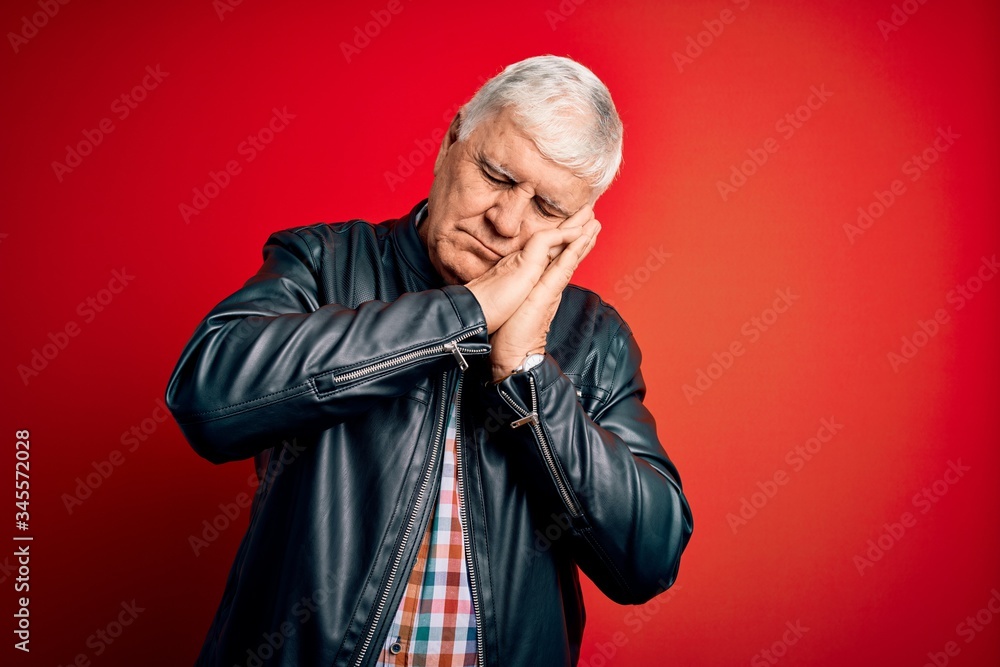 Senior handsome hoary man wearing casual shirt and jacket over isolated red background sleeping tired dreaming and posing with hands together while smiling with closed eyes.