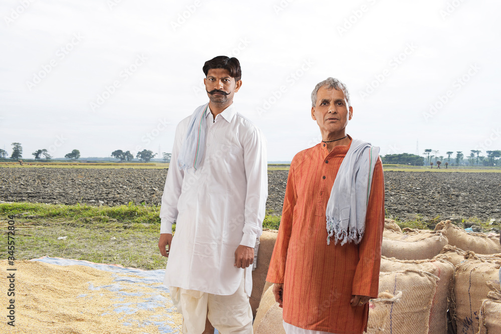 Portrait of two farmers standing in field
