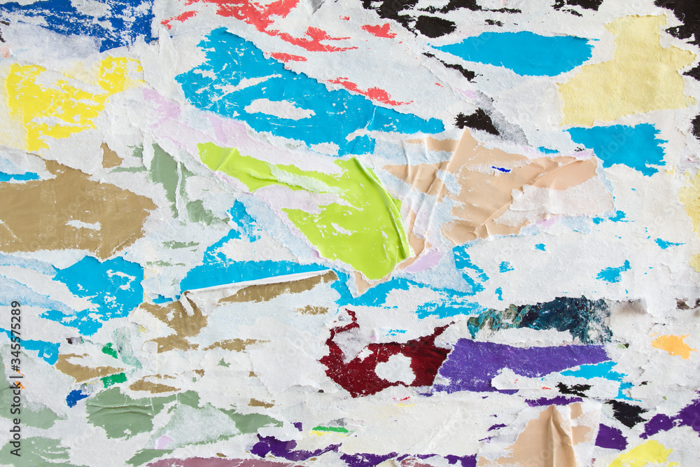 Bright motley torn crumpled and peeling pieces of old paper placard and poster layers on billboard texture background. Bright motley torn crumpled and peeling pieces of old paper placard and poster layers on billboard texture background.