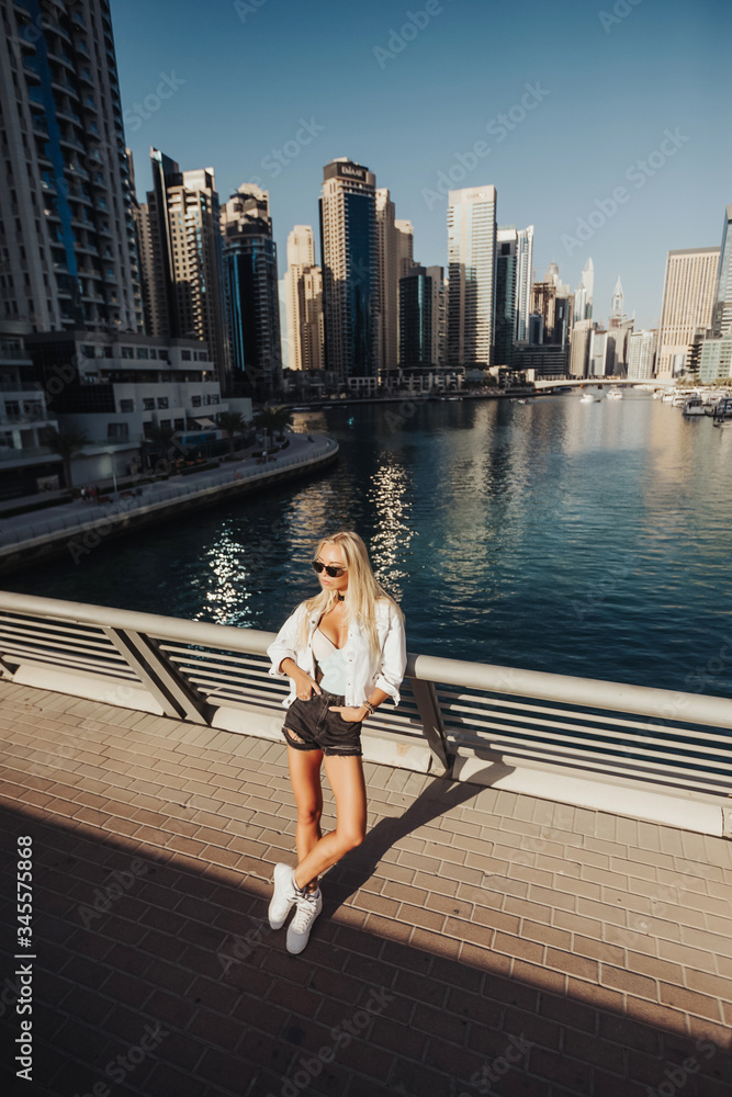 Bright and clean overlooking lake view in an urban city emirates gulf country lifestyle. Russian lady photography in the city with tall building in surroundings tourist spot of Dubai.